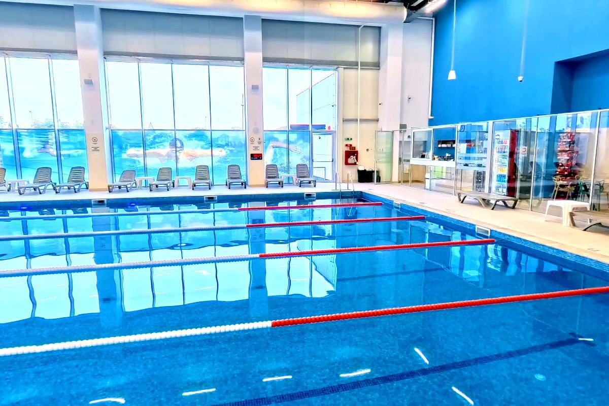 The semi olympic pool at AquaFit Spa, lane ropes running away toward a wall of windows