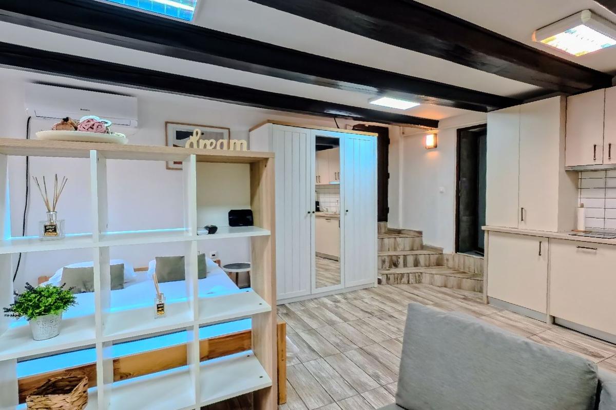 The long white room at Brassai Apartments under dark stained beams