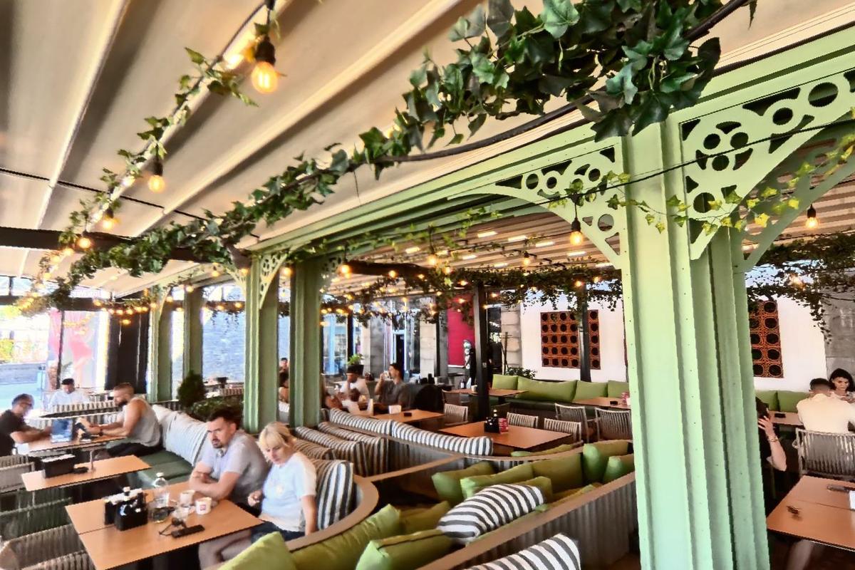 The long terrace at Marty Westside under ivy and sage green columns