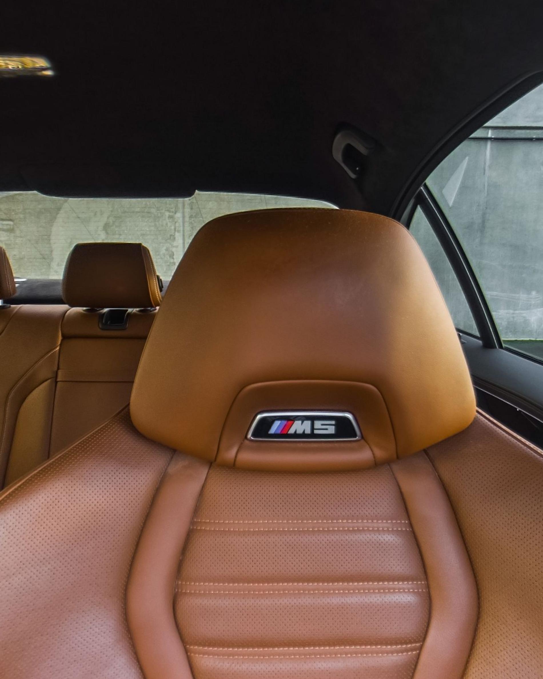 The front seat in cognac leather with an M5 badge on the headrest