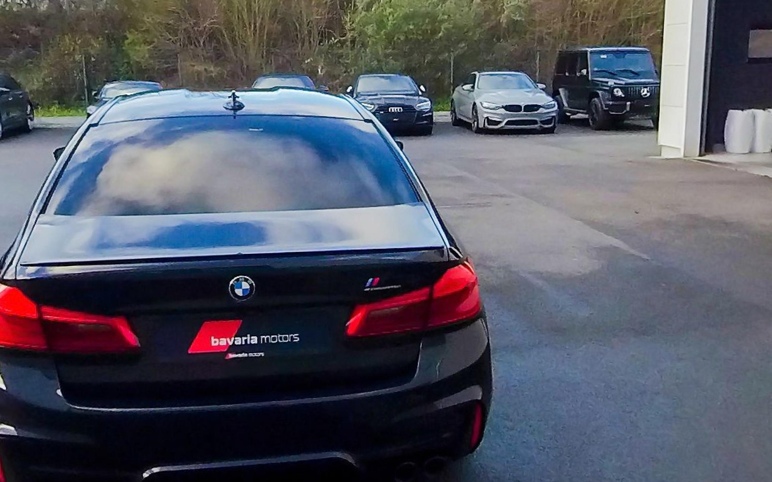 The car head on from the rear, tail lights and boot