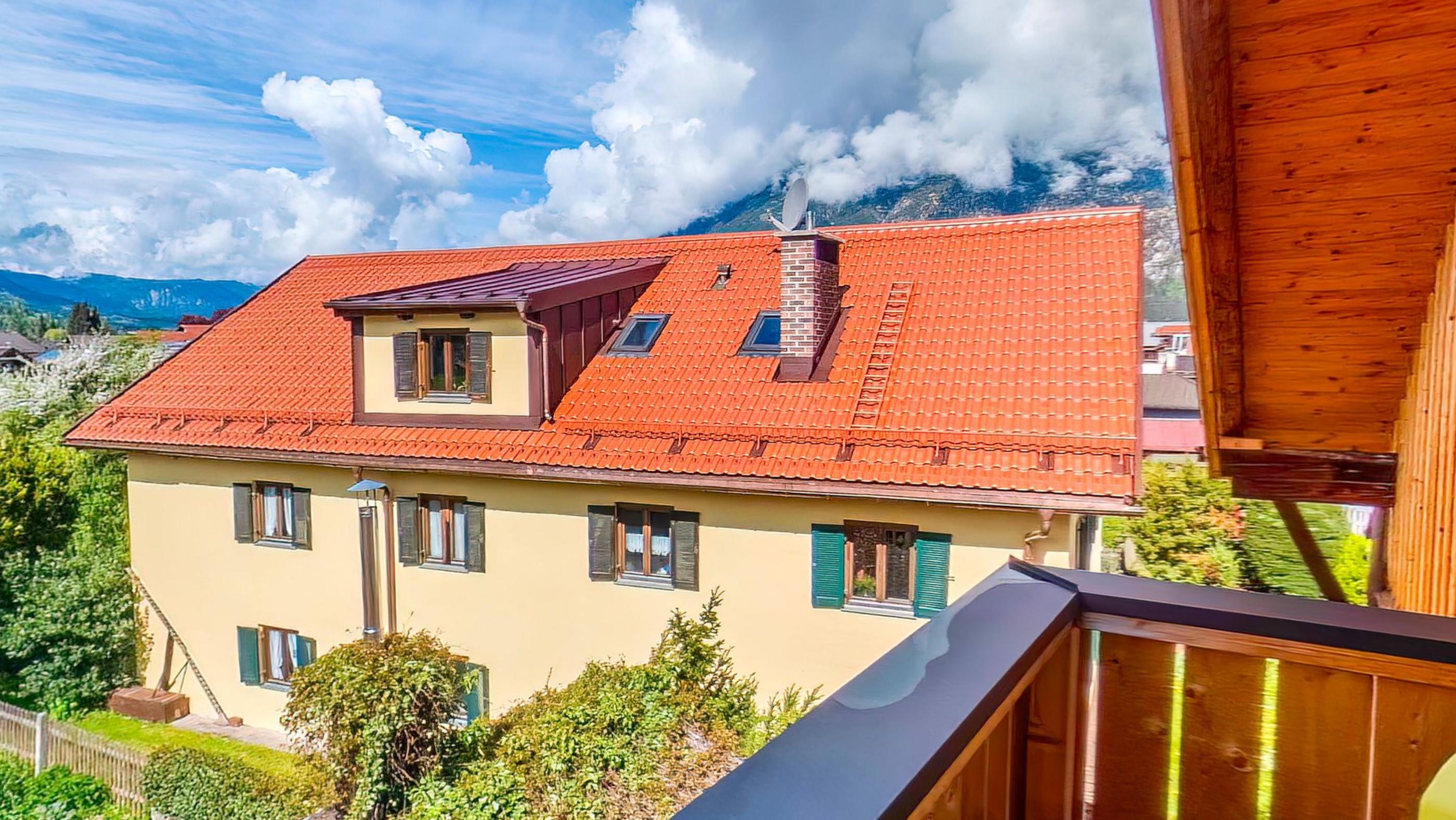 Red tiled roofs of the village below the balcony with the mountains rising behind them