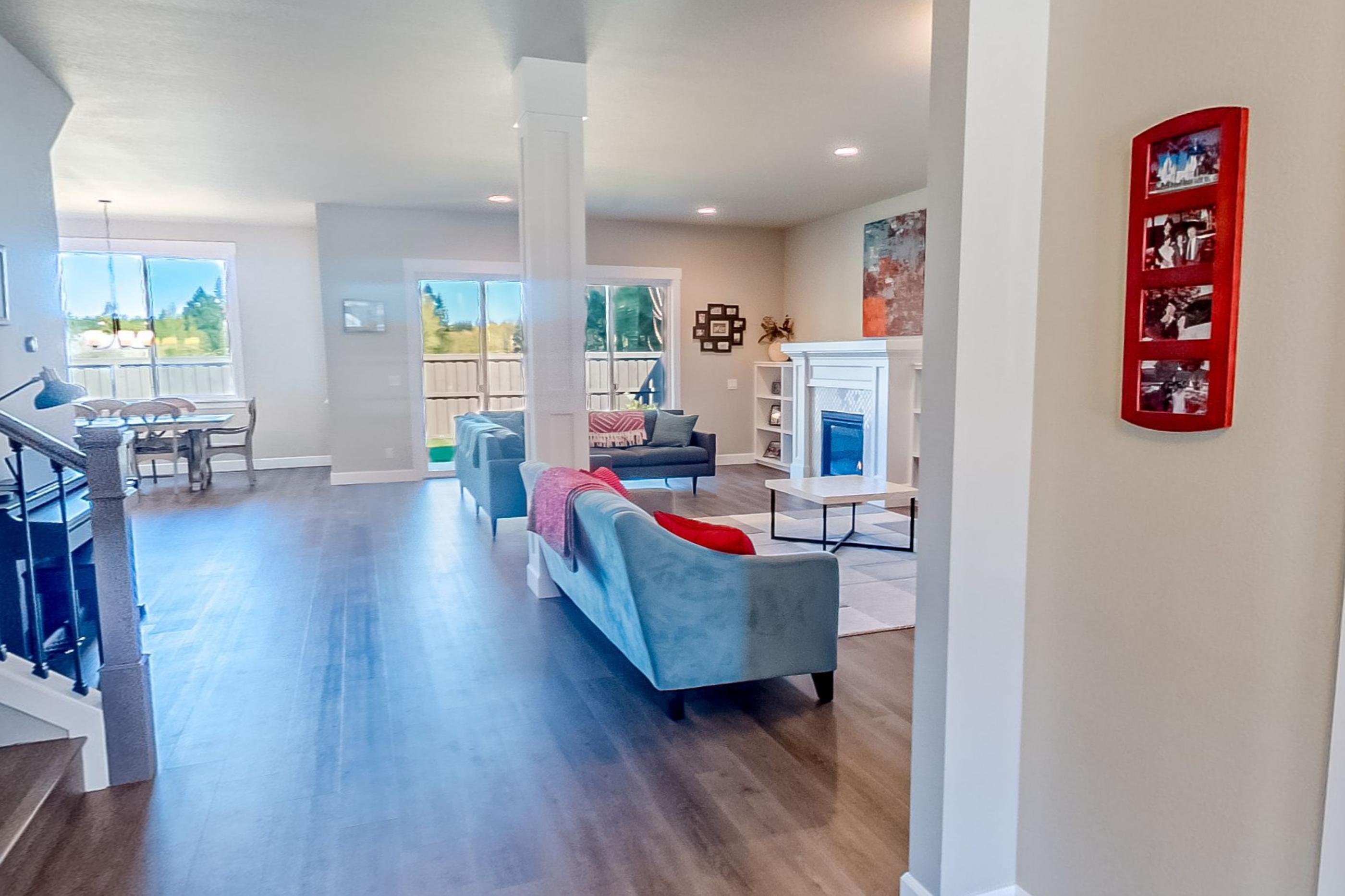 The entrance looking straight through into the open living space with a teal sofa