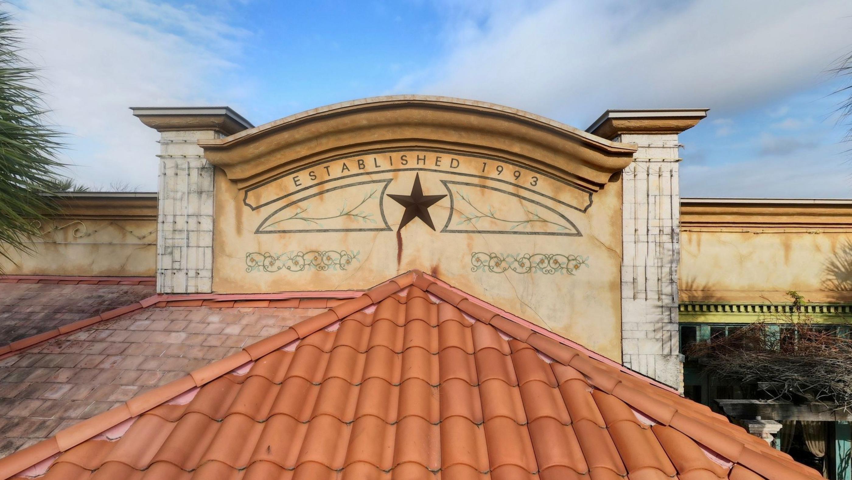 The tiled roof and carved stone facade of the restaurant with a star above the entrance