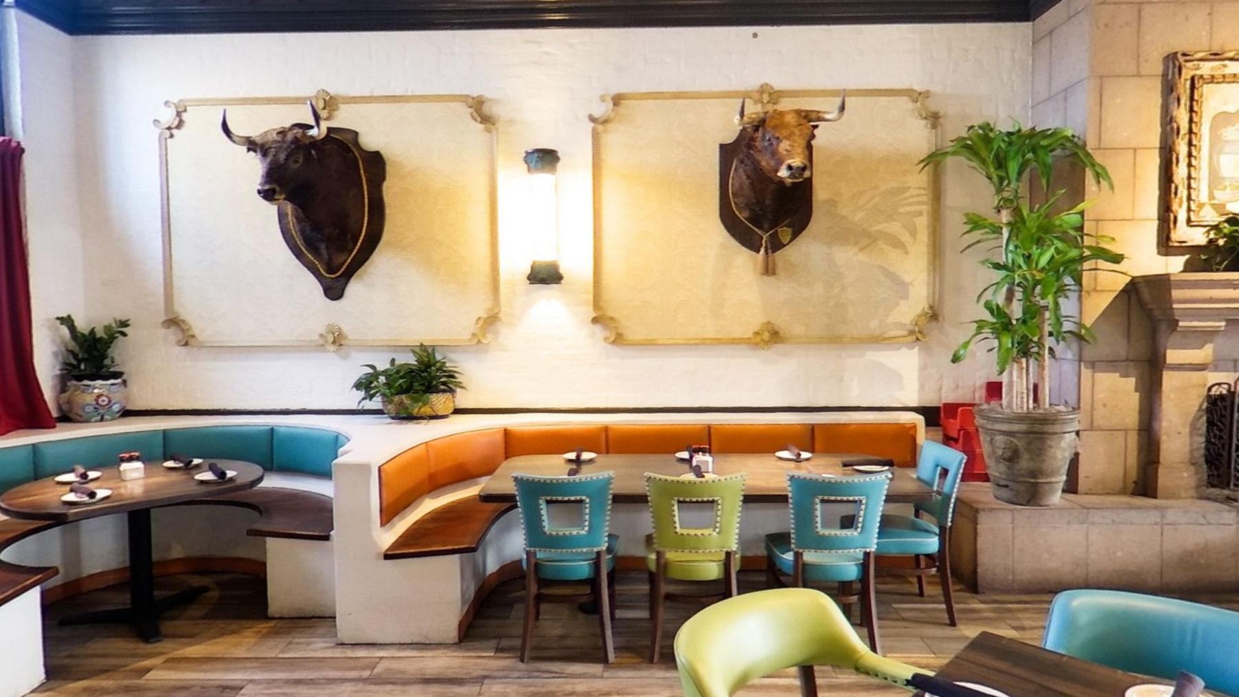 A curved teal and orange booth set against carved stone