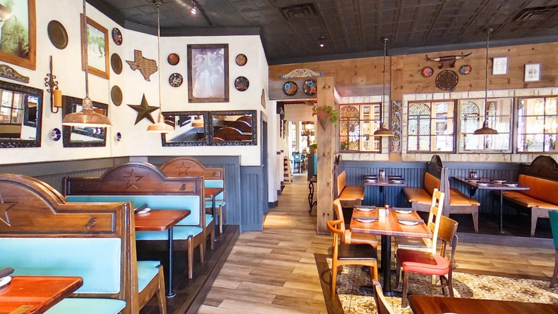 Teal booths beneath a wall covered in framed pictures