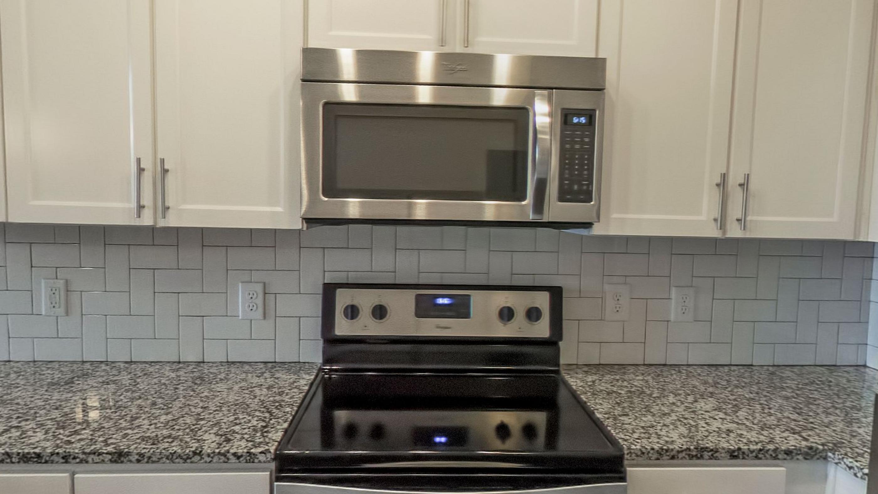 An apartment kitchen with tiled splashback