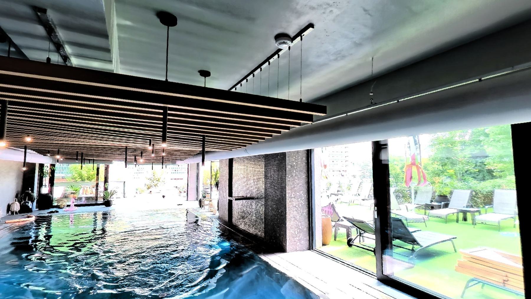 The indoor pool under a dark ribbed ceiling