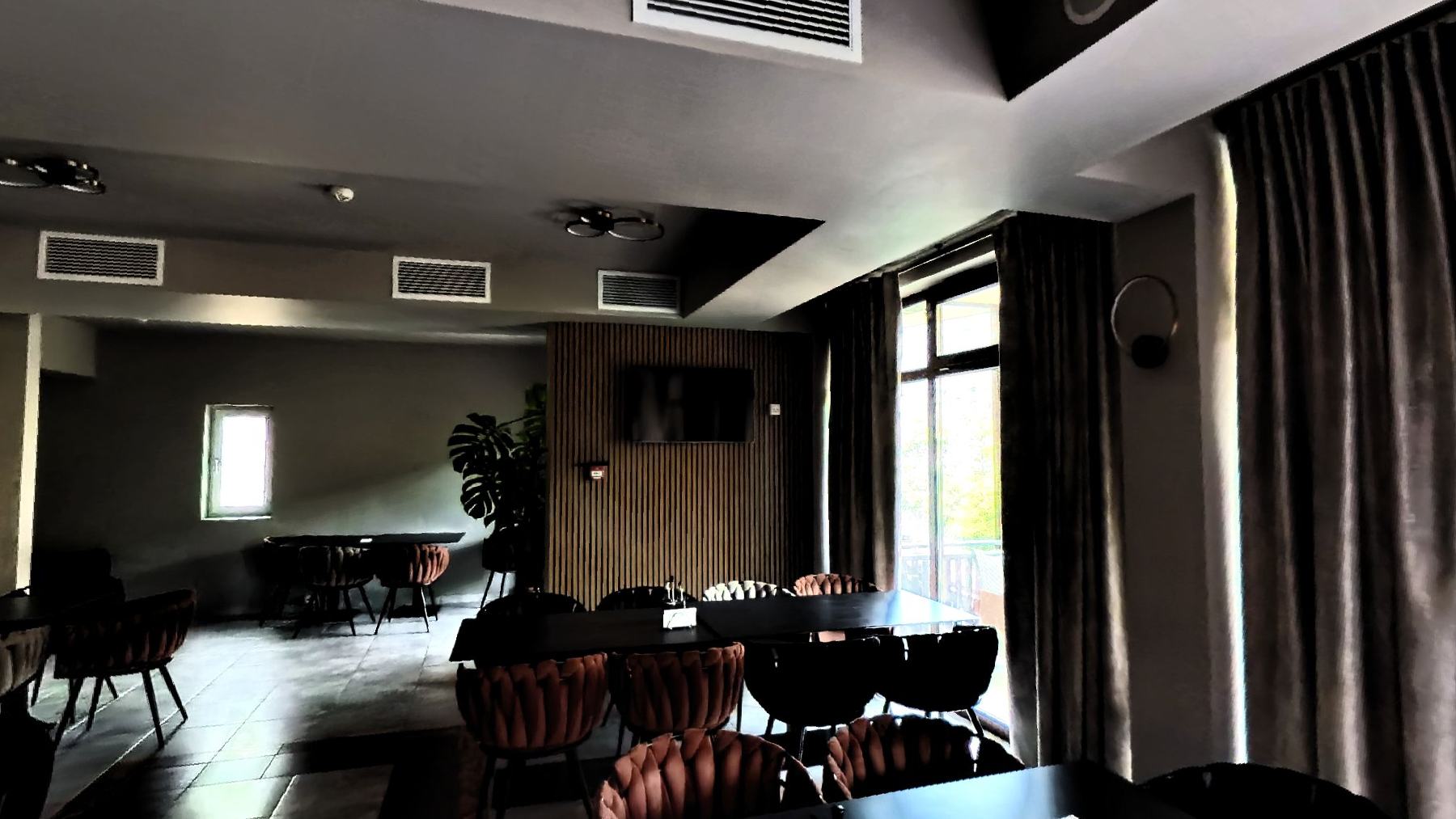 The restaurant with laid tables and tall curtained windows