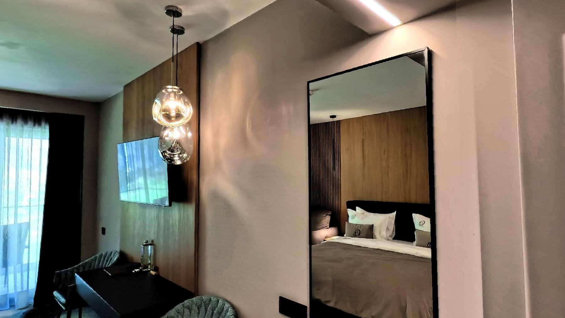 A double room with a wide bed and warm lamps