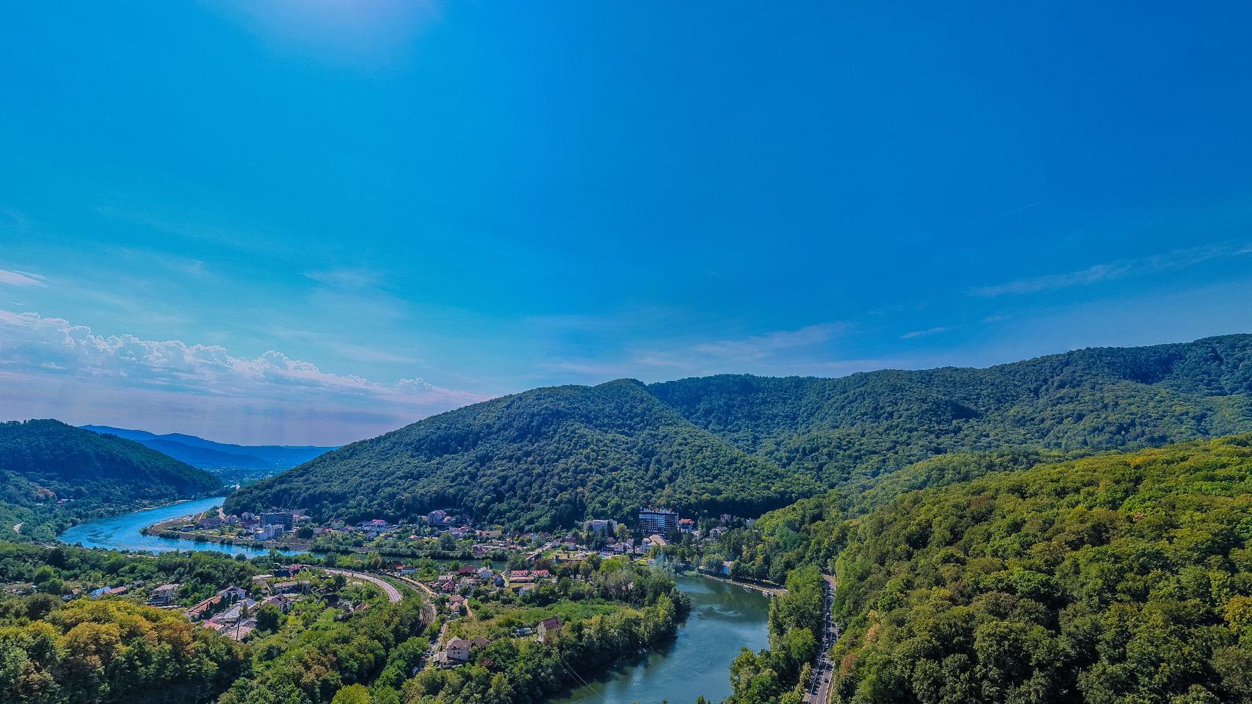 The Olt valley from above, forested hills on both sides and the river running through