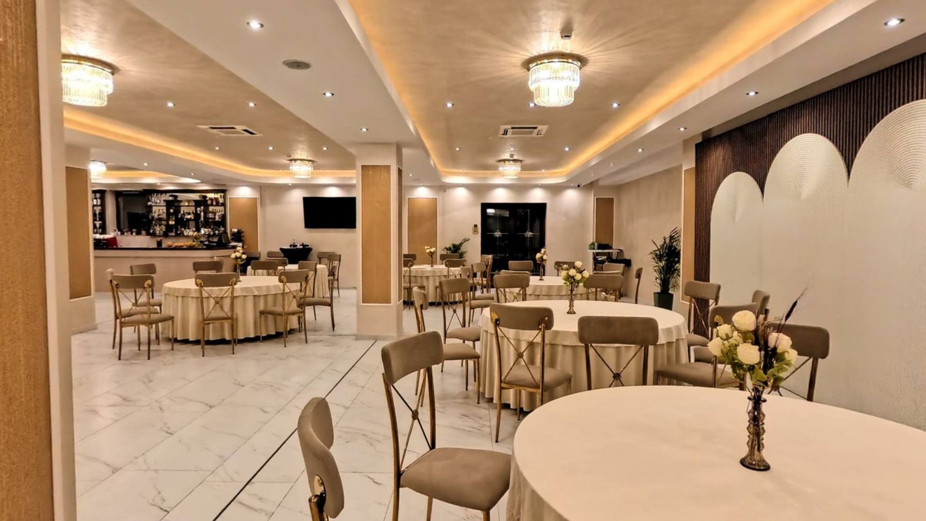 The hotel restaurant with laid tables under soft ceiling light