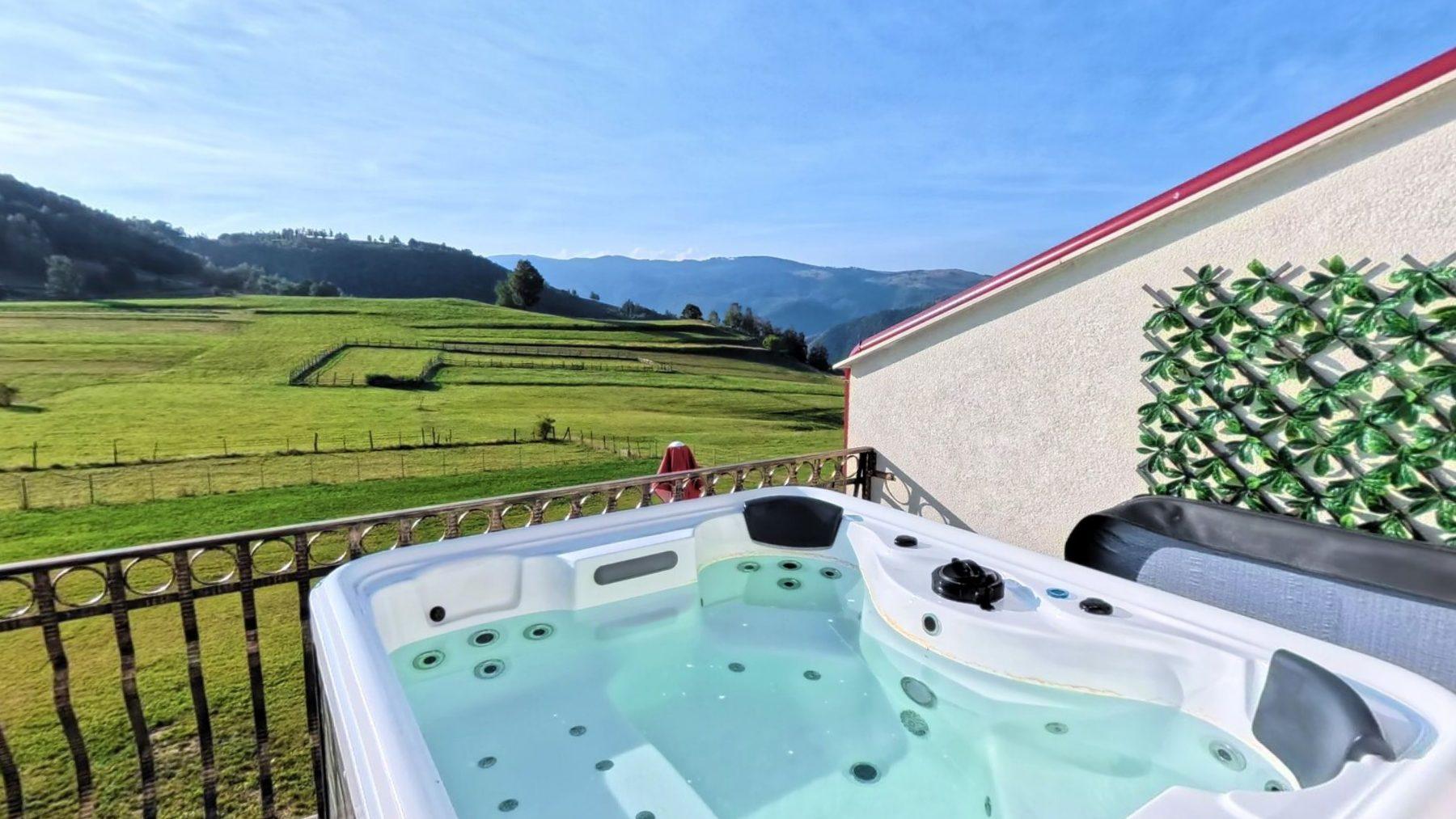 The finished terrace with the hot tub full and the mountains behind