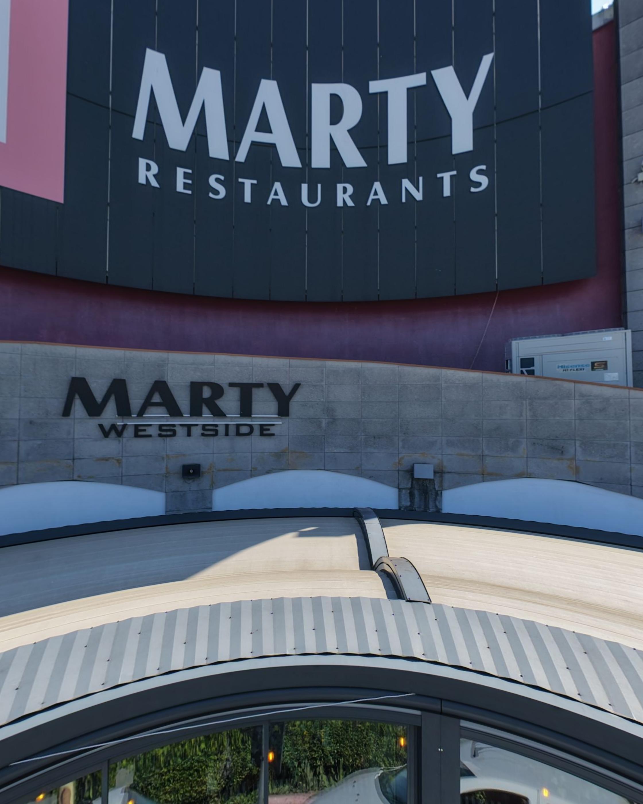 The Marty Restaurants and Marty Westside signs on the building outside