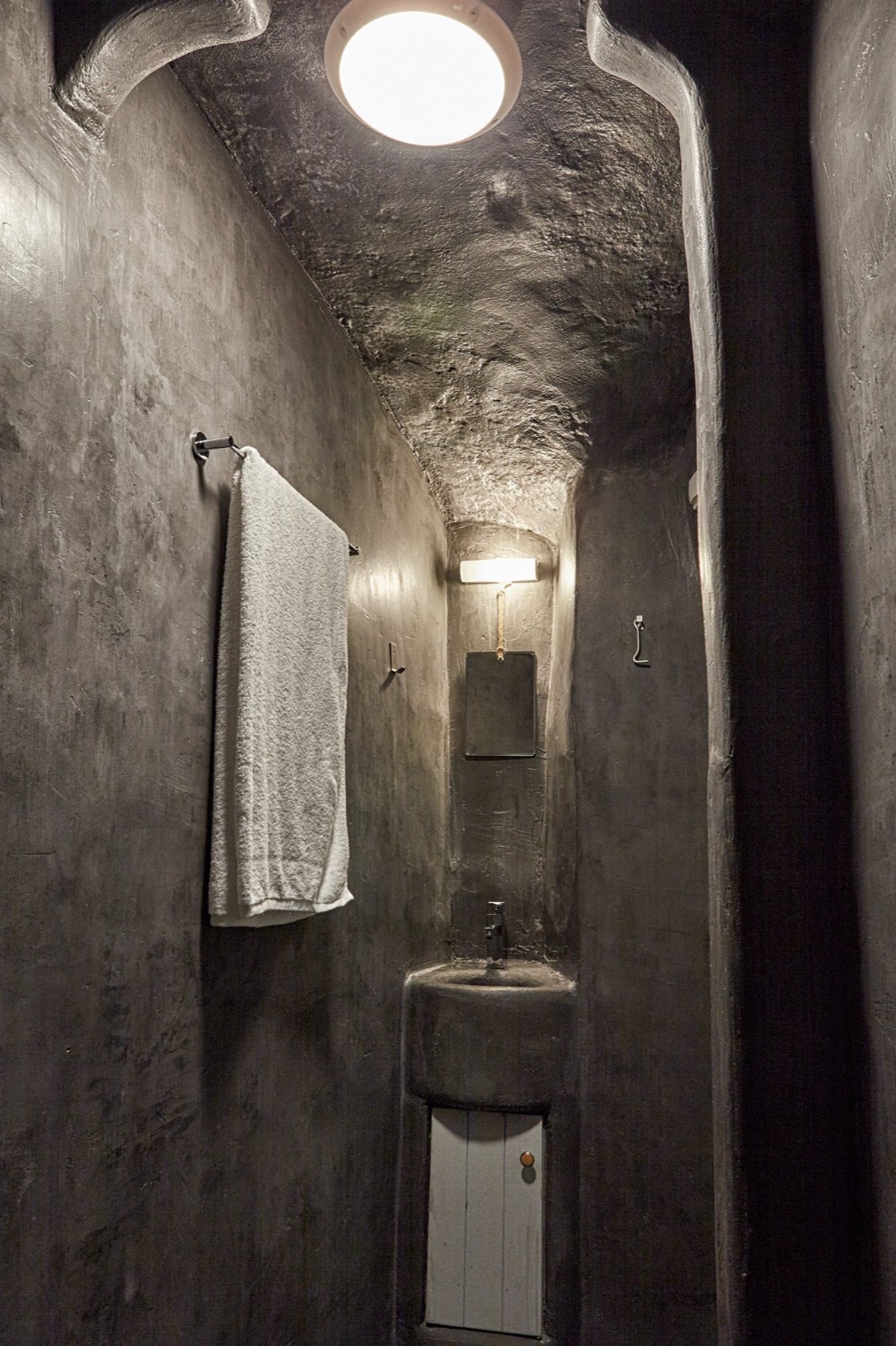 Narrow carved passage leading to the washbasin under a skylight