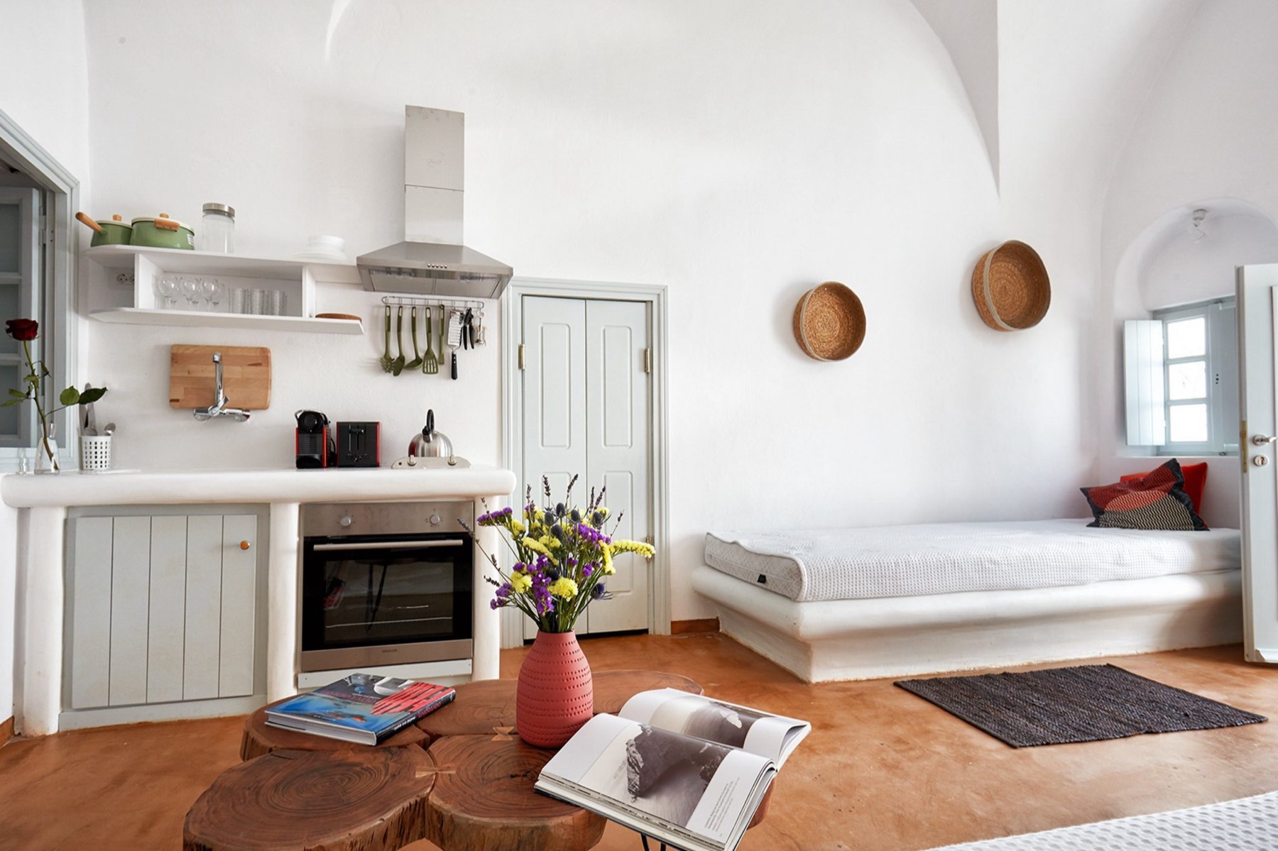 Compact white kitchen with an oven, a coffee machine and a built-in daybed